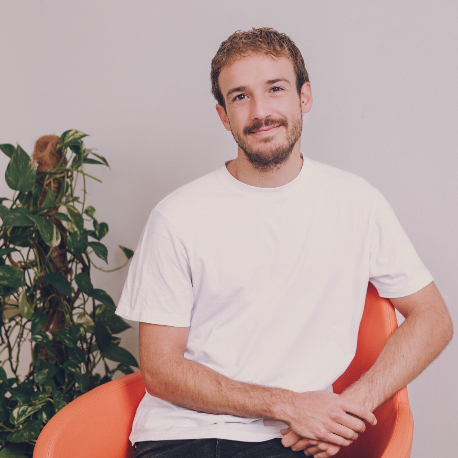 Hombre sonriendo con confianza, en un espacio bien iluminado